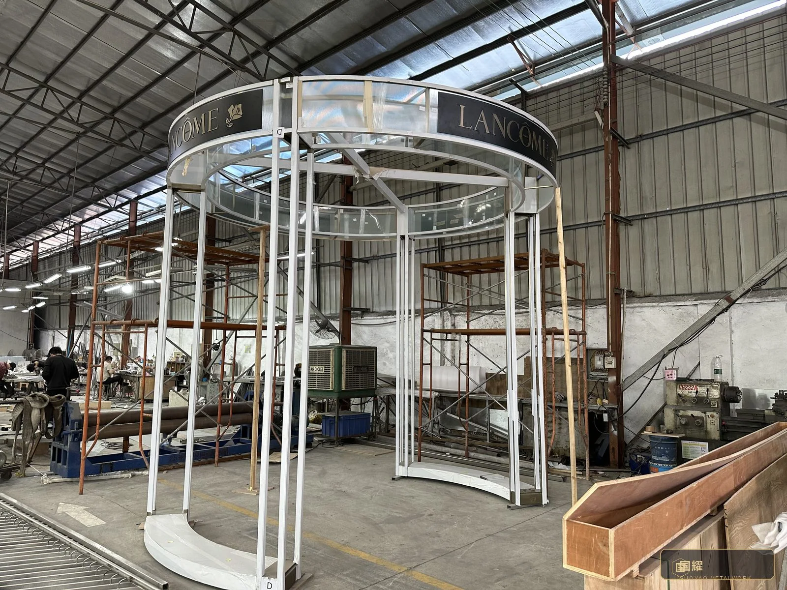 Curved white columns and ring beam seen across the workshop