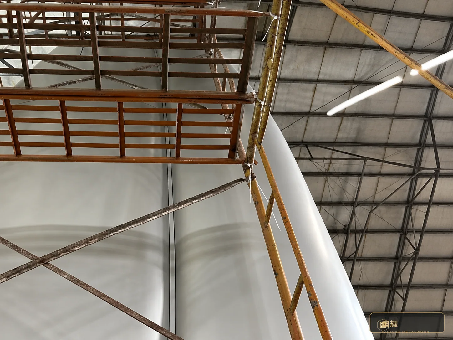 The finished surface checked under raking light against the scaffold