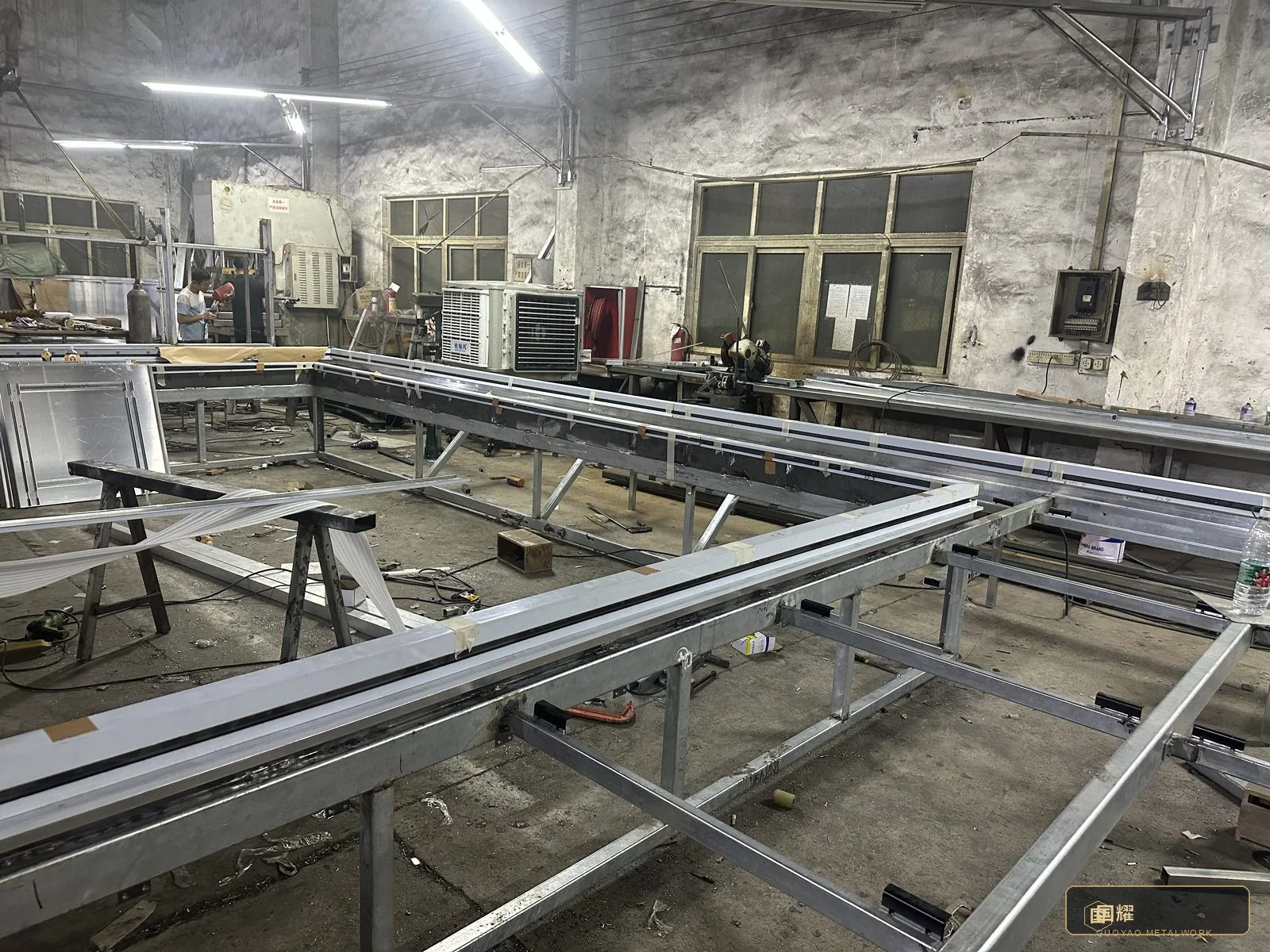 Sub-frame bays on the workshop floor — base and head rails aligned to the survey dimensions before final welding.