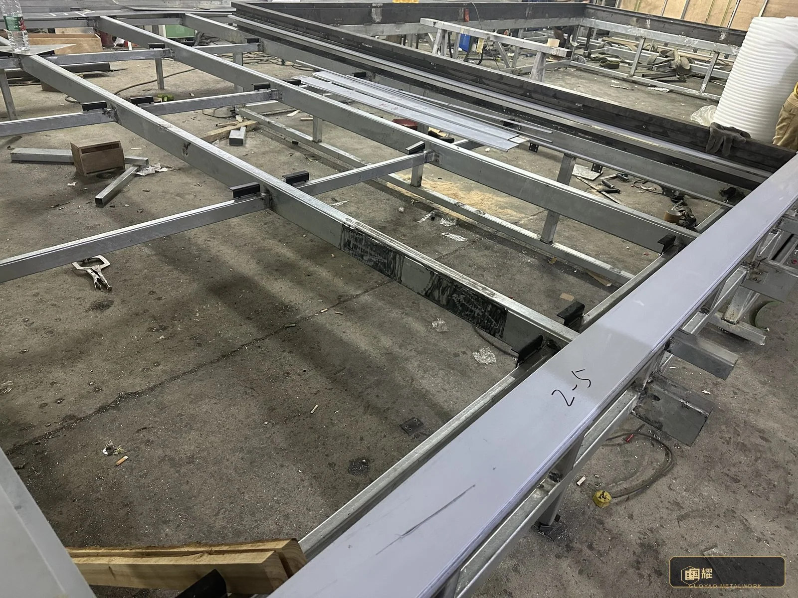 Finished bays laid out in the fabrication hall, sequenced for packing and installation in the same order they will meet the slab.