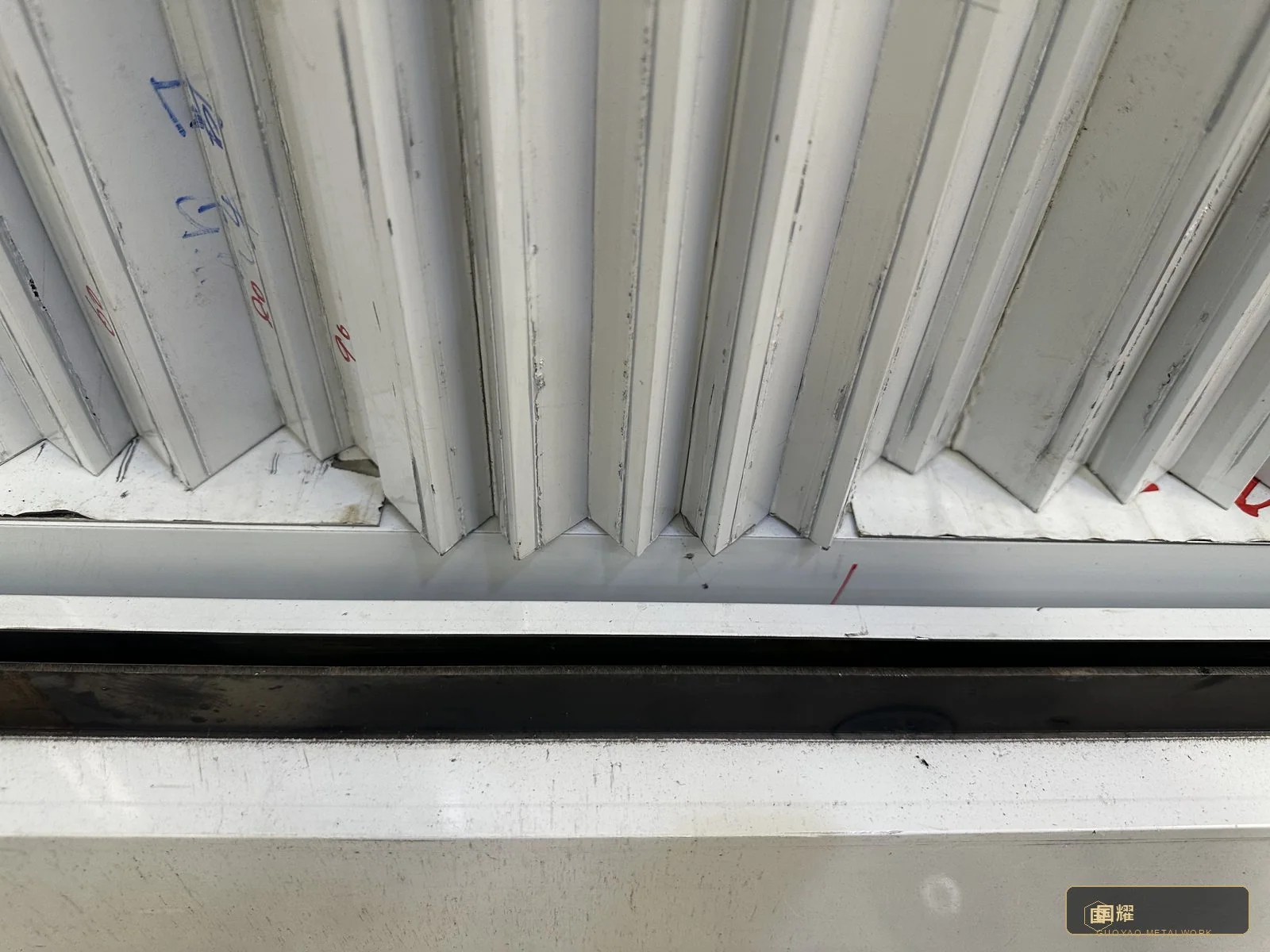 Panels meeting the frame: a fluted module offered up to its bay, edges protected, engraved reference facing the fitter.
