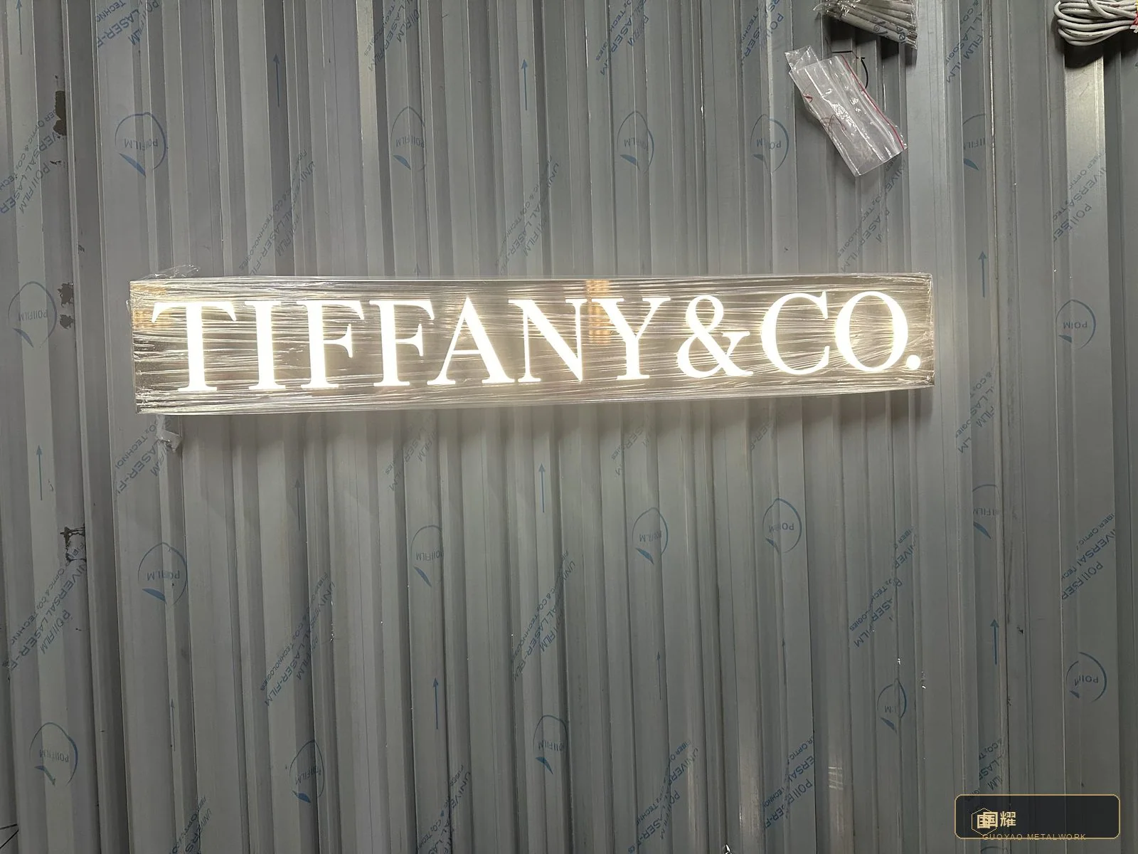The name seen straight-on at the bench — typographic profiles, spacing and glow checked against the brand specification.