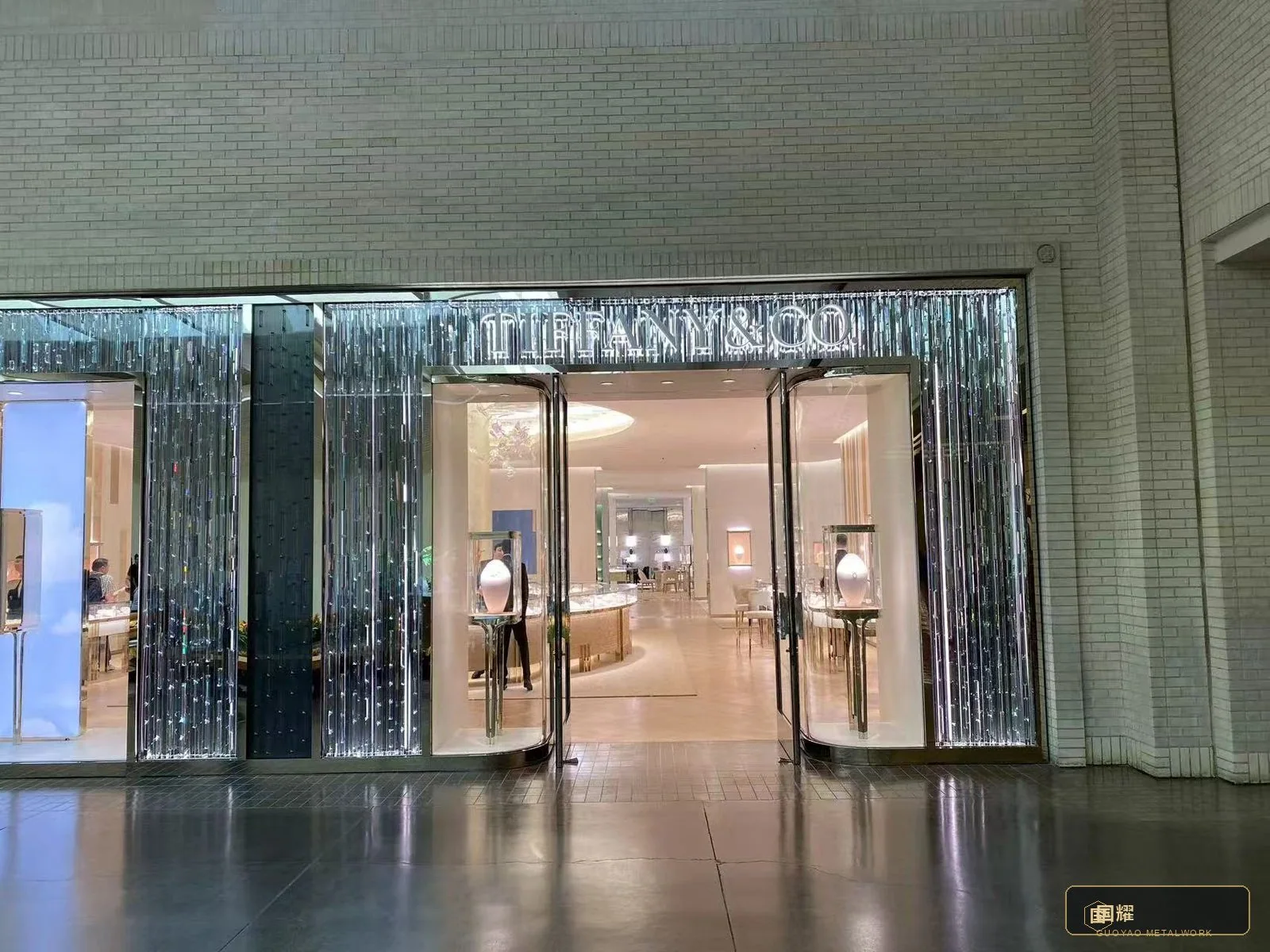 The entrance in daily use: the facade performing as background architecture for the brand's windows and doors.