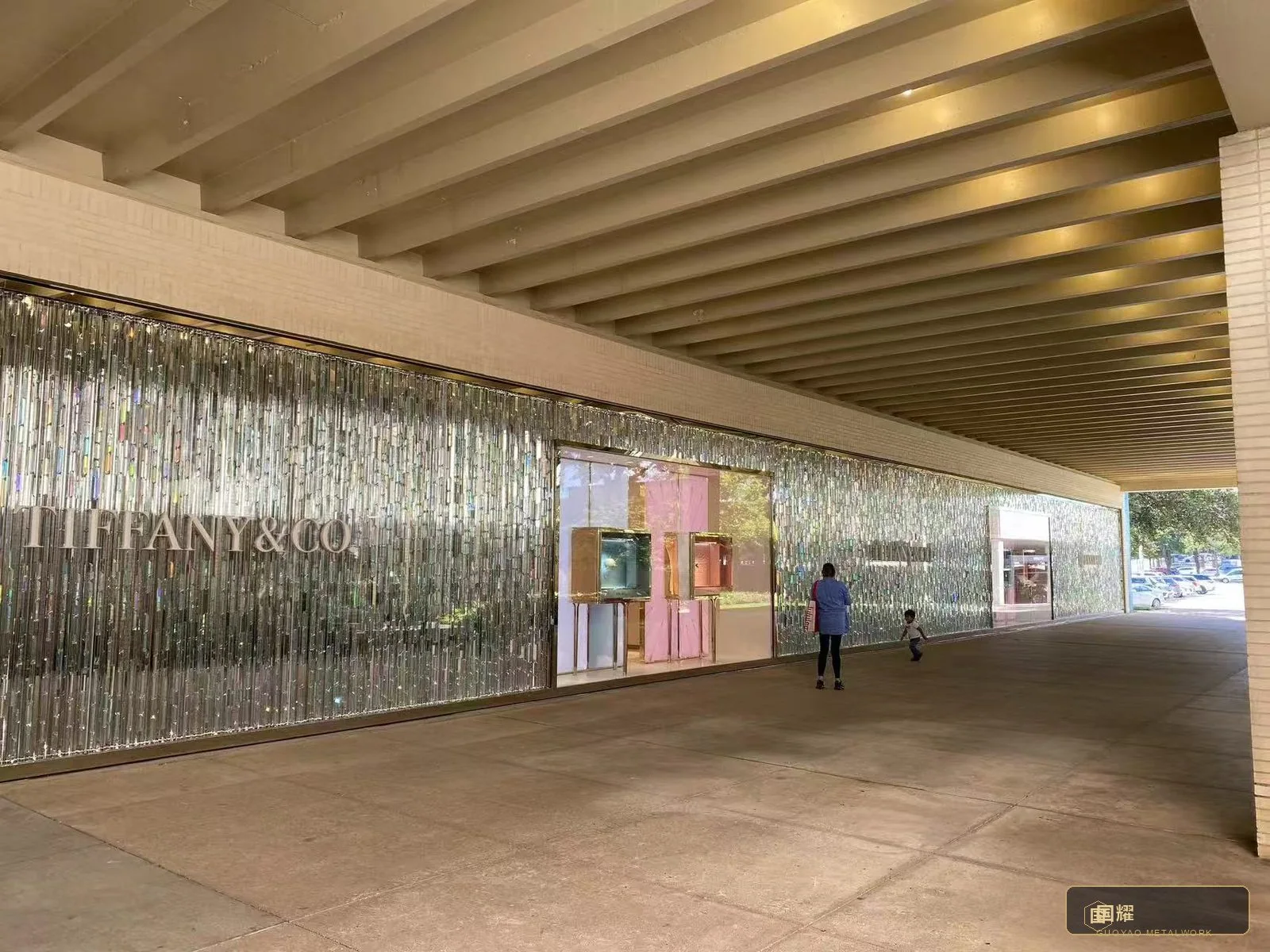 The completed wall run in daylight — the silver flutes holding their rhythm across every module.